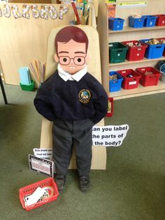 a boy is sitting in a chair with his hands on his hips and wearing glasses