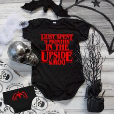 a baby bodysuit with the words just spent 9 months in the upside down on it