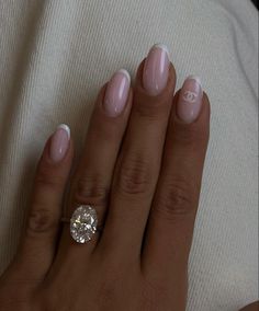 a woman's hand with french manies and a diamond ring on her finger