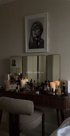 a vanity with candles and pictures on the wall