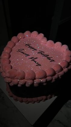 a birthday cake with pink frosting and sparkles in the shape of a heart