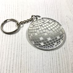 a silver disco ball keychain sitting on top of a table