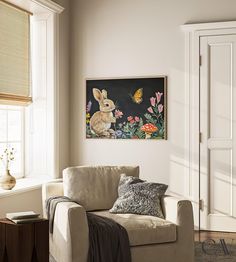 a living room filled with furniture and a painting hanging on the wall over a window