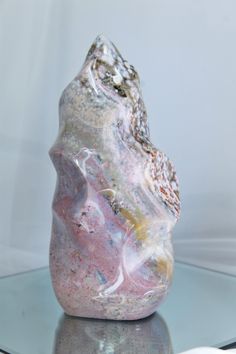 This gorgeous Ocean Jasper flame comes from Madagascar and displays the most pastel hues of pink, purple, yellow, and blue.  Size: 6.5in tall x 3.1 in wide  Weight: 2lb, 10oz Ocean Jasper aspires to relieve our stress and tension while uplifting feelings of relaxation reminding us that we are safe and protected. A stone that instills happiness, Ocean Jasper inspires feelings of joy by aiding the release of negative emotions and thought patterns. Ocean Jasper Meaning Crystal Healing, Ocean Jasper Crystal Meaning, Ocean Jasper Bracelet, Ocean Jasper Jewelry, Geode Rocks, Ocean Jasper Crystal, Pretty Rocks, Cool Rocks, Ocean Jasper