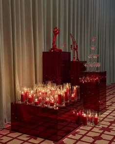 many candles are lit in glass containers on the floor