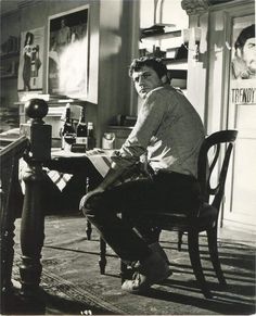 a man sitting at a table with a bottle of wine