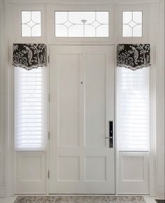 the front door is decorated with black and white curtains, along with two matching valances