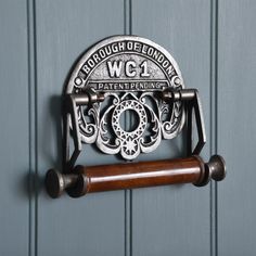 an old fashioned toilet paper dispenser hangs on the wall next to a blue door