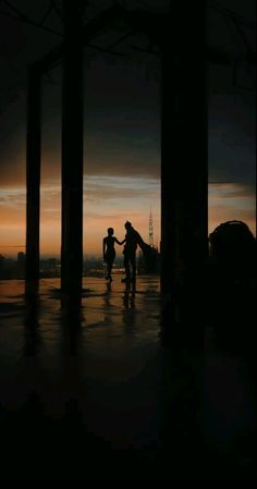 two people are walking in the dark with their skateboards