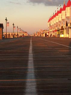 a row of buildings sitting next to each other on top of a pier at sunset