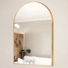 an arched mirror hanging on the wall above a white couch