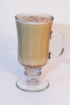 a glass cup filled with liquid sitting on top of a table