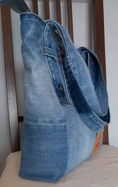 a denim bag sitting on top of a wooden chair