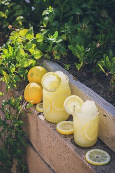 some lemons are sitting on the side of a window sill next to glass jars