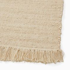 a beige rug with fringes on the top and bottom side, against a white background