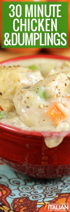 a red bowl filled with chicken and dumplings on top of a colorful table cloth