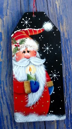 a painted christmas ornament hanging on a wooden wall