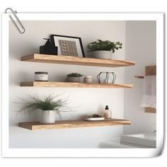 three wooden shelves with plants and pictures on them in a white walled bathroom, along with a toilet