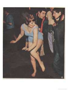 a woman in a blue leotard is dancing with other people