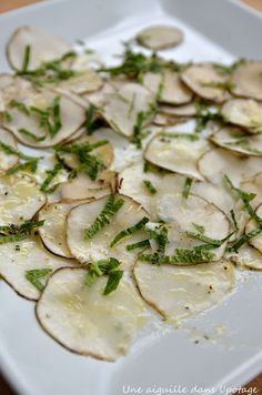 a white plate topped with potato chips covered in herbs