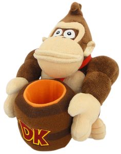 a stuffed toy monkey sitting on top of a barrel with the word ok in it's mouth