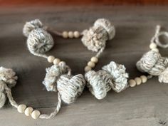 several crocheted beads are arranged on a wooden surface, including one bead