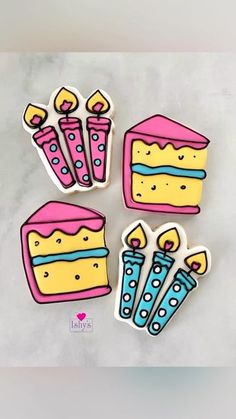 four pieces of cake stickers sitting on top of a white surface with blue and yellow icing