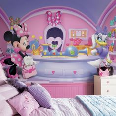 a child's bedroom decorated in pink and purple with minnie mouse wall decals