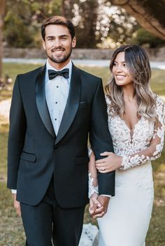 a man in a tuxedo and a woman in a wedding dress holding hands