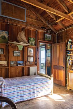 a bedroom with wood paneling and pictures on the walls, along with a bed