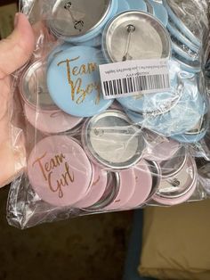 a person is holding a bag full of badges and magnets that say team y'all