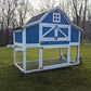 a blue and white chicken coop sitting in the grass