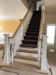 a staircase with carpeted steps in an empty house under construction, during the day