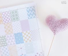 a heart shaped lollipop sitting on top of a piece of paper next to it