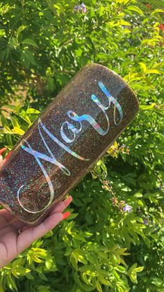 a hand holding up a glittered wine bottle with the word merly written on it