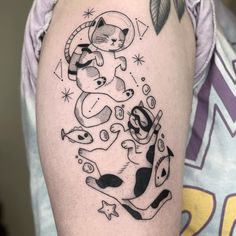 a black and white cat tattoo on the left upper arm, with stars in the background