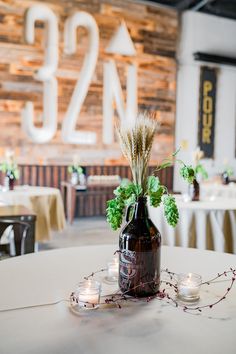 a vase with flowers and greenery sits on a table