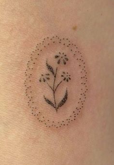 a small tattoo on the back of a woman's stomach with flowers in it