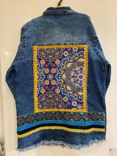 Reworked boho inspired denim jacket with embellished back panel. Hand crafted tapestry style panel with beautiful trimmings and velvet ribbon. Bohemian Denim Outerwear With Multicolor Embroidery, Bohemian Patchwork Denim Jacket For Fall, Bohemian Blue Denim Jacket With Pockets, Bohemian Denim Jacket With Pockets For Fall, Bohemian Embroidered Blue Denim Jacket, Bohemian Blue Embroidered Denim Jacket, Bohemian Denim Outerwear With Pockets, Bohemian Embroidered Multicolor Denim Jacket, Bohemian Cotton Denim Vest For Festivals