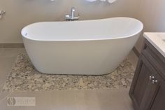 a white bath tub sitting on top of a bathroom floor