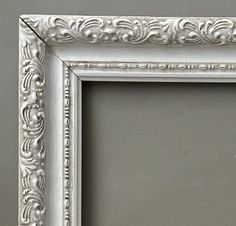 an ornate silver frame on a gray wall