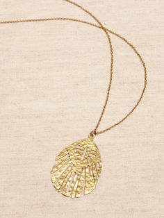 WANDERLUST COLLECTION: Designed to capture our love of adventure—it speaks to the places traveled and those yet to visit.  The pieces are hand-crafted by skilled artisans with authentic materials.  The Abstract Leaf Pendant adds an enticing touch of the exotic to any outfit.  Made of hammered brass with slight variations in tone and polish.  Lobster clasp.  Length: 18" (45. 7cm) with 2" extender. Brass Heart Pendant Necklace With Lobster Clasp, Elegant Pendant Shell Necklace With Lobster Clasp, Elegant Shell-shaped Necklace With Lobster Clasp, Bohemian Teardrop Pendant Necklace With Lobster Clasp, Gold-tone Pendant Jewelry With Lobster Clasp, Abstract Leaf, Hammered Brass, Leaf Pendant, Gold Pendant Necklace