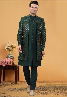 Art Silk Sherwani in Dark Green This Readymade attire is Enhanced with Buttons, Resham and Stone Work. Crafted in Chinese Collar Neck and Full Sleeve Available with an Art Silk Pant in Dark Green and an Art Silk Long Jacket in Dark Green Do note: Bottom Style and Footwear shown in the image is for presentation purposes only. Half to one inch may vary in measurement. (Slight variation in actual color vs. image is possible) Bottle Green Sherwani For Men, Green Indo Western Outfits, Western Outfits For Men, Indian Wedding Clothes For Men, Indo Western Sherwani, Sherwani Groom, Sherwani For Men, Kurta Men, Mens Kurta Designs