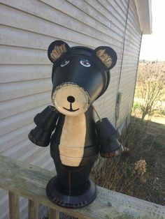 a black bear statue sitting on top of a wooden fence