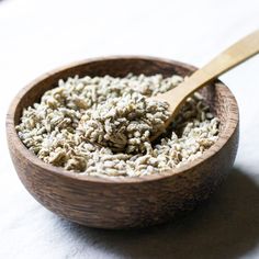 a wooden bowl filled with oatmeal on top of a white tablecloth