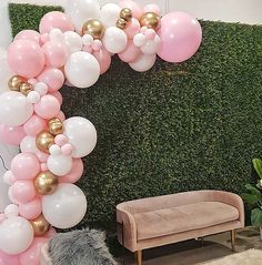 the balloon arch is decorated with pink, white and gold balloons in front of a green wall