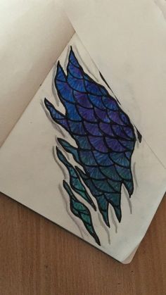 a piece of paper that has some kind of fish on it with blue and purple colors