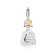 a silver and gold bell charm on a white background with the word sterling tequila written in it