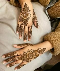 two hands with henna tattoos on them