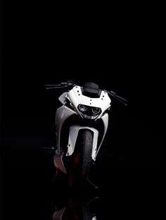 a white motorcycle parked on top of a black floor